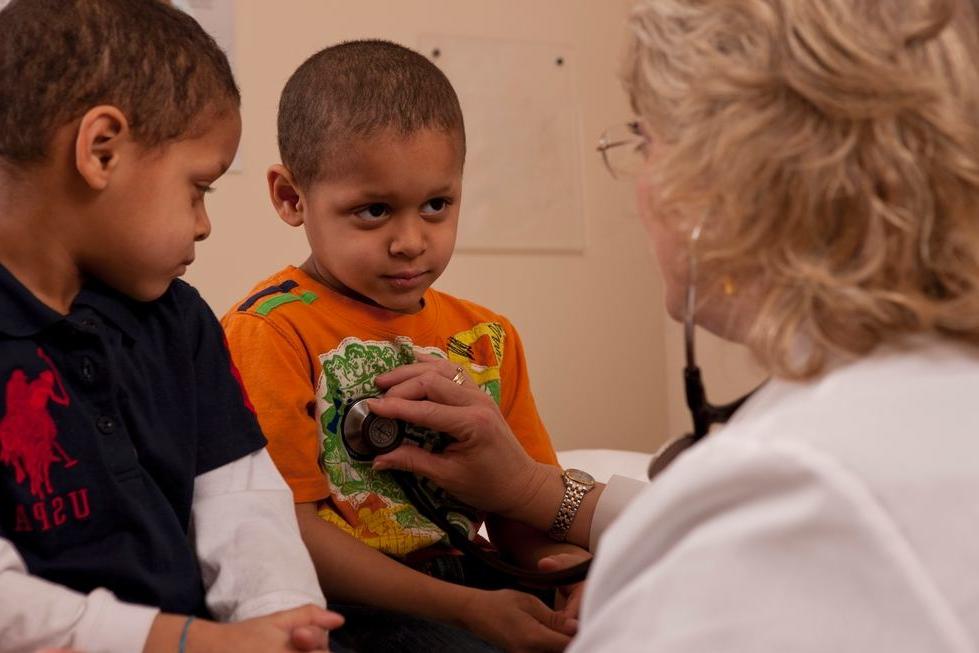 Two young boys being examined by a clinician